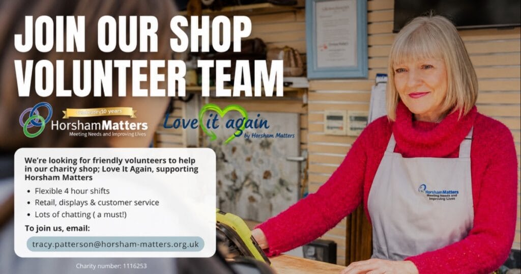 Woman in a red cardigan standing outside a shop with a volunteer recruitment poster asking people to join the shop volunteer team