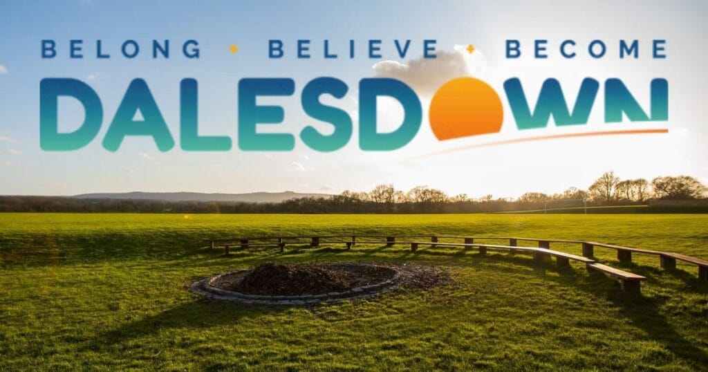Landscape scene with a grassy field, a stone circle in the foreground and the word Dalesdown across the sky