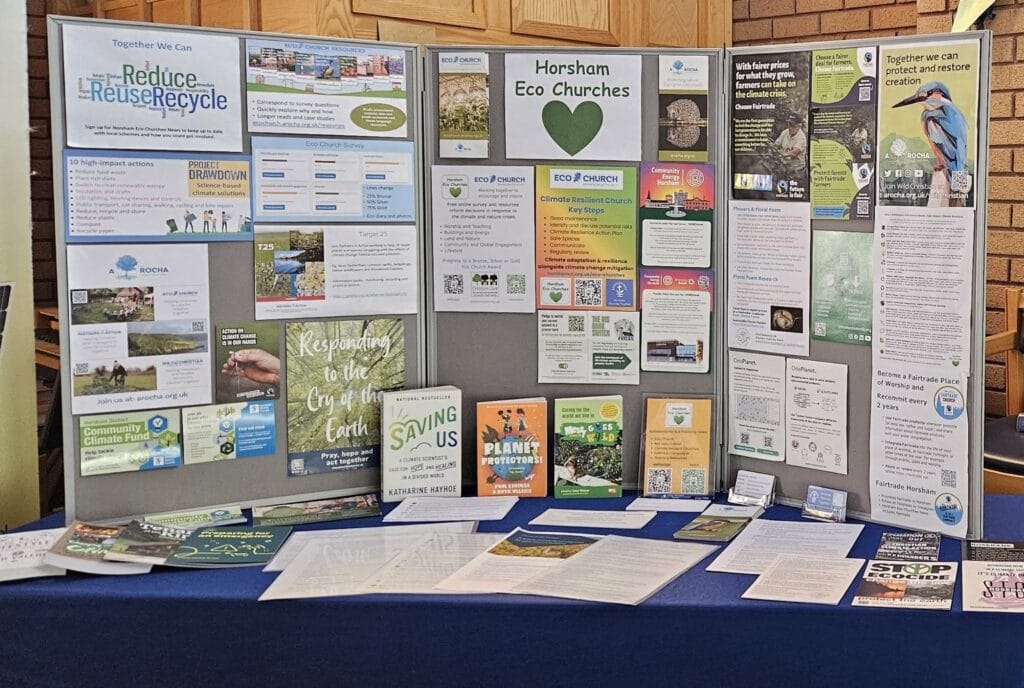 Eco Churches stall A display board with many eco and conservation leaflets and posters on a table, including a title about habitat change and recycling information