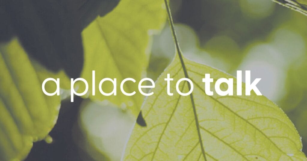 Green leaves with the words a place to talk overlaid on a blurred background