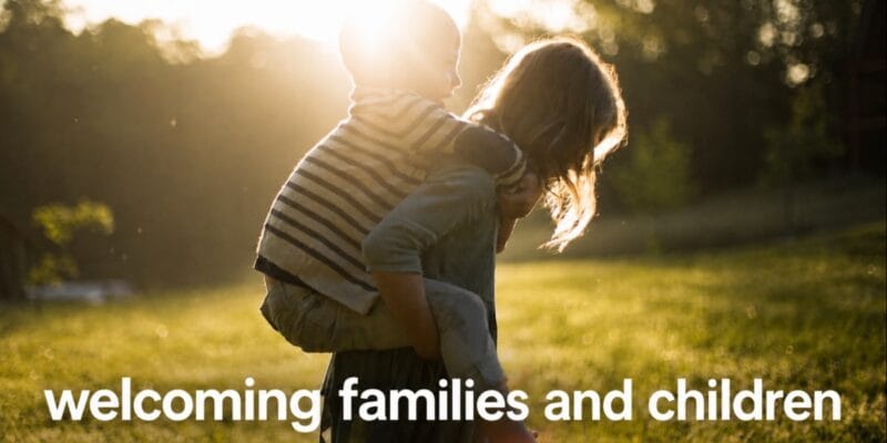Woman carrying a child piggyback outdoors; text reads “welcoming families and children”