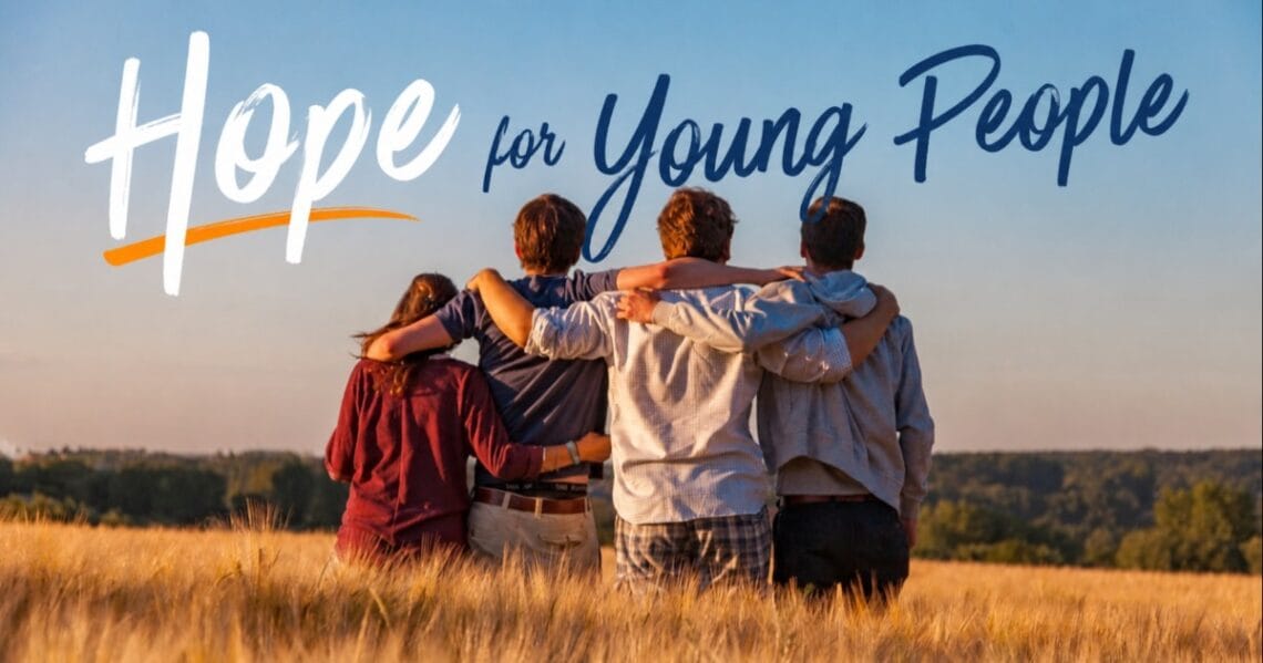 Four people standing arm in arm in a field beneath the text Hope for Young People