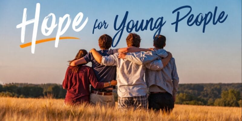 Four people standing arm in arm in a field beneath the text Hope for Young People