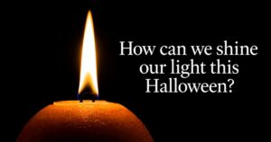 Lit orange candle beside text reading “How can we shine our light this Halloween?”