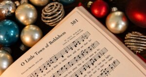 Sheet music titled O Little Town of Bethlehem surrounded by Christmas ornaments