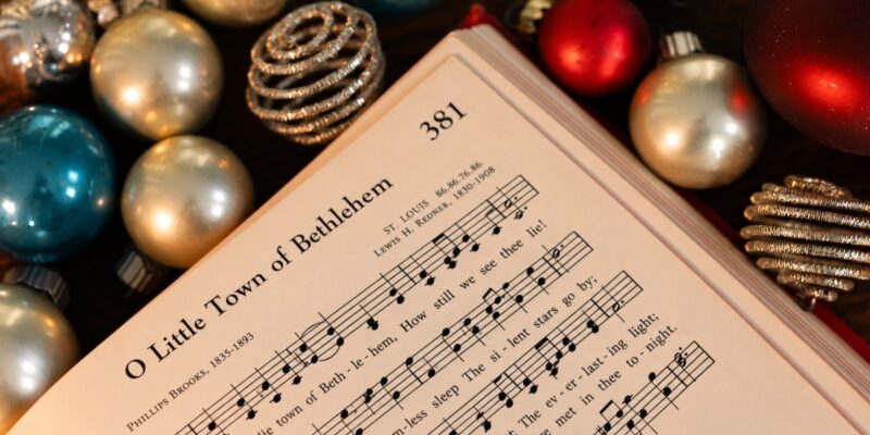 Sheet music titled O Little Town of Bethlehem surrounded by Christmas ornaments